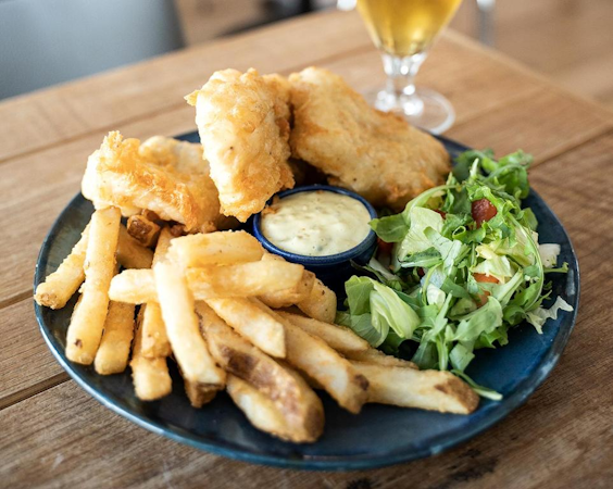 Enjoy a meal of freshly-caught seafood with chips, salad, and a beer to wash it down at the Fisherman Guesthouse Sudureyri.
