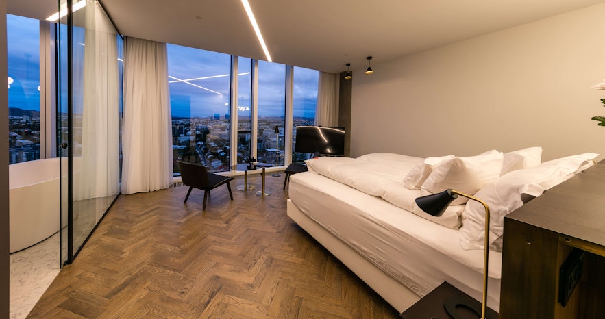 A bedroom with floor-to-ceiling windows at Tower Suites Reykjavik.