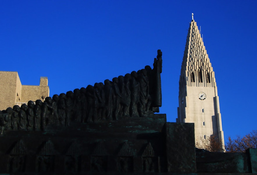 A bronze sculpture designed by Einar Jonsson, with the tower of the Hallgrimskirkja church behind it.