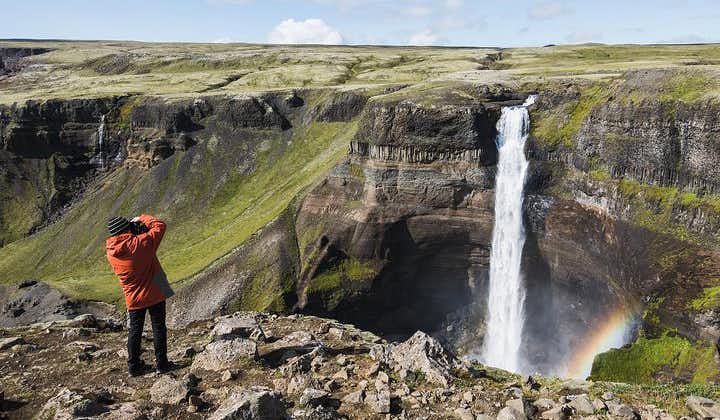 A man takes a picture of Haifoss waterfall, one of Iceland's highest waterfalls.