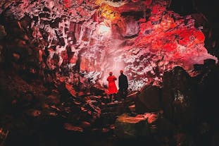 Two people enjoy the view of the interior of a lava tunnel on the Reykjanes Peninsula in Southwest Iceland.