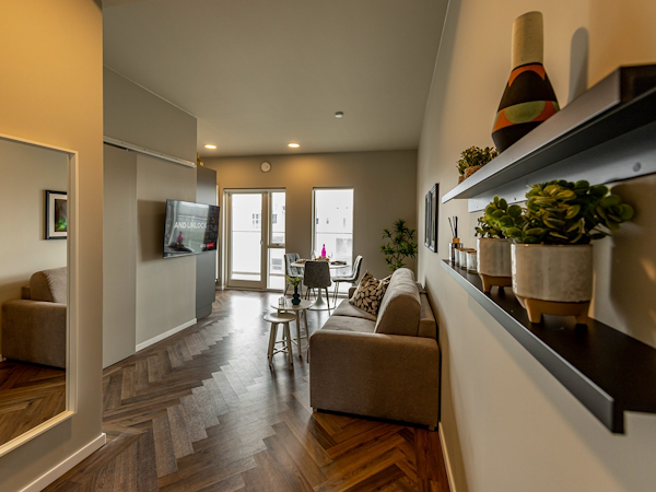 The open-plan living and dining area at SJF Apartments viewed from the doorway.