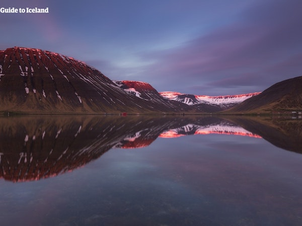 Serene reflections: Majestic mountains mirrored in the tranquil waters of Hornstrandir Nature Reserve.