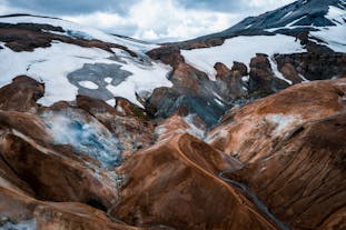 The Kerlingarfjoll mountain range features rolling caramel-colored peaks streaked with color and splattered with snow.