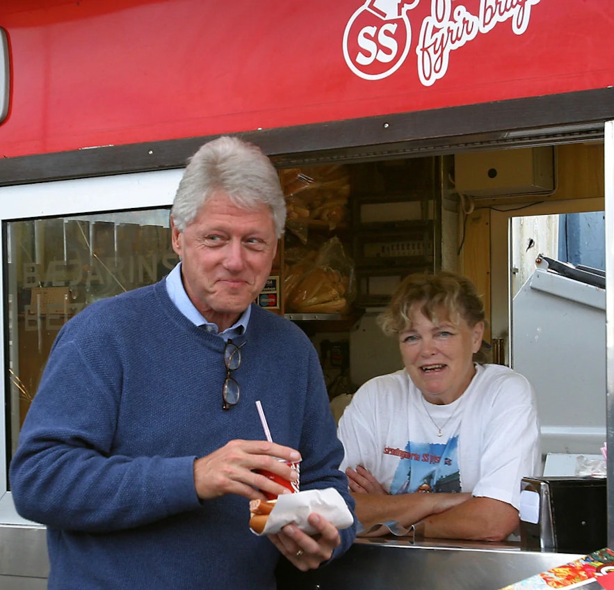 Former US president Bill Clinton enjoys a hot dog at Bæjarins Beztu, made by legendary hot dog server Mæja