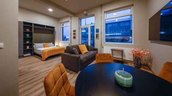The studios at Center Apartments have an open-plan living space with a kitchenette, sofa, and bed.