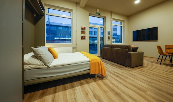 A bed, sofa, and flatscreen TV in one of the studios at Center Apartments in Reykjavik.