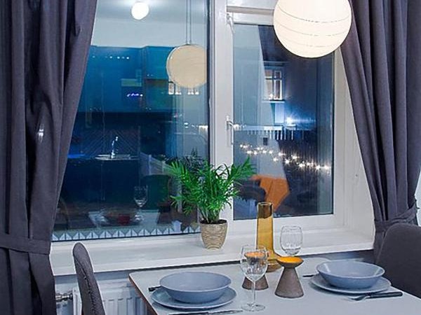 The dining table is laid with tablewear and wine glasses at Astro Apartments.