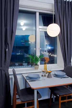 The dining table is laid with tablewear and wine glasses at Astro Apartments.