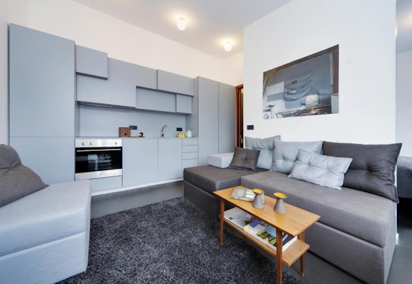An open-plan living space with a kitchen and sofa at Astro Apartments in central Reykjavik.