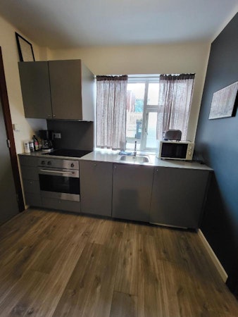 A kitchenette with a stove, oven, toaster, and microwave at Astro Apartments in central Reykjavik.