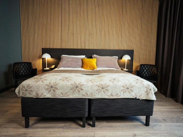 A double bed with nice linen and bedside lamps at Konvin Hotel by Keflavik Airport.