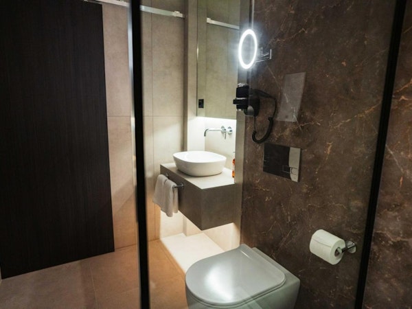A modern bathroom with a toilet and basin at Konvin Hotel by Keflavik Airport.