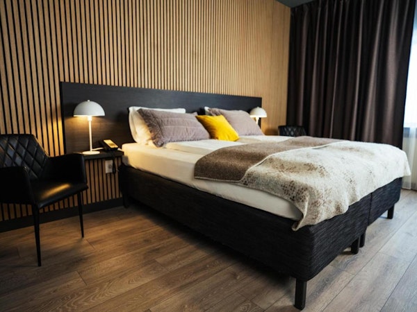 A double bed with nice linen and bedside lamps at Konvin Hotel by Keflavik Airport.