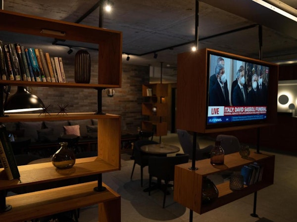 The common area with a television, books, and seating at Konvin Hotel near Keflavik Airport.