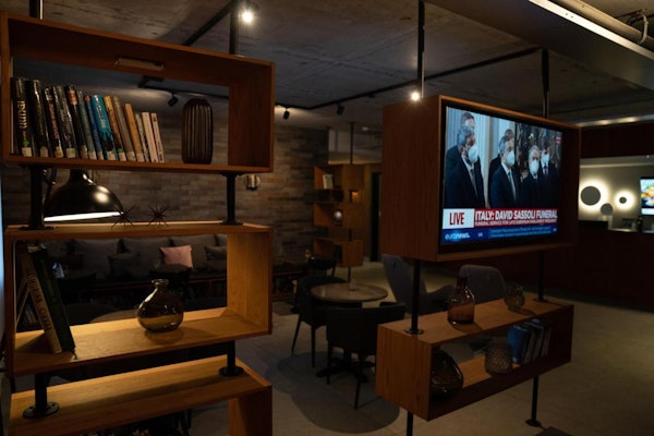 The common area with a television, books, and seating at Konvin Hotel near Keflavik Airport.