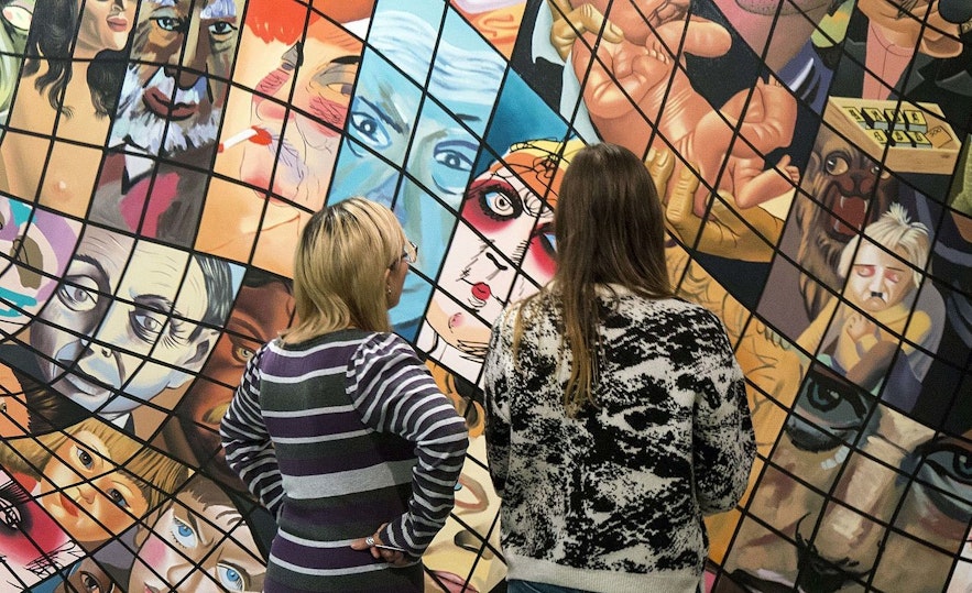 访客正在欣赏Hafnarhús分馆内冰岛画家Erró的画作。