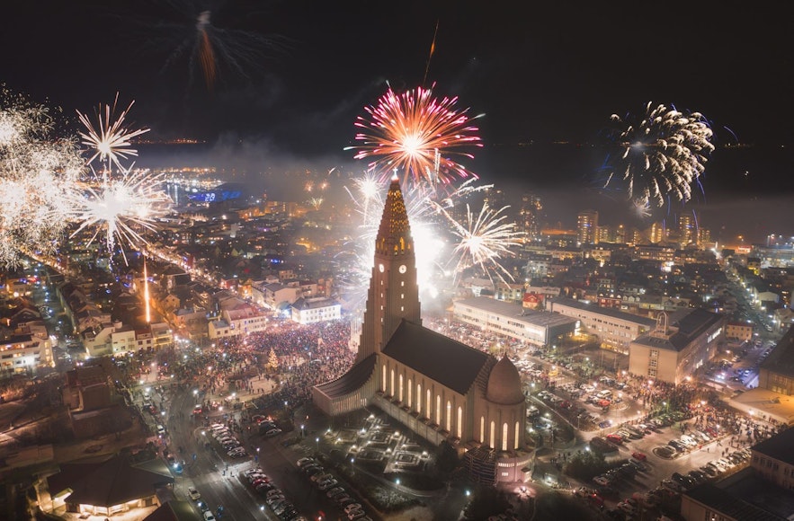 Hallgrimskirkja in Reykjavik during New Years Eve, with many different fireworks lighting up the night sky