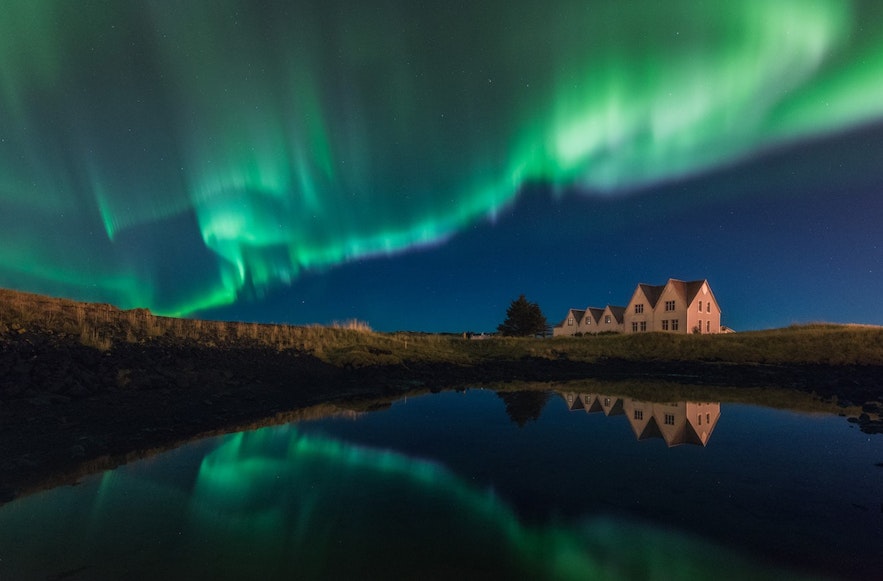 Aurora boreale nel cielo sopra una casa a Straumur sulla penisola di Reykjanes in Islanda in inverno