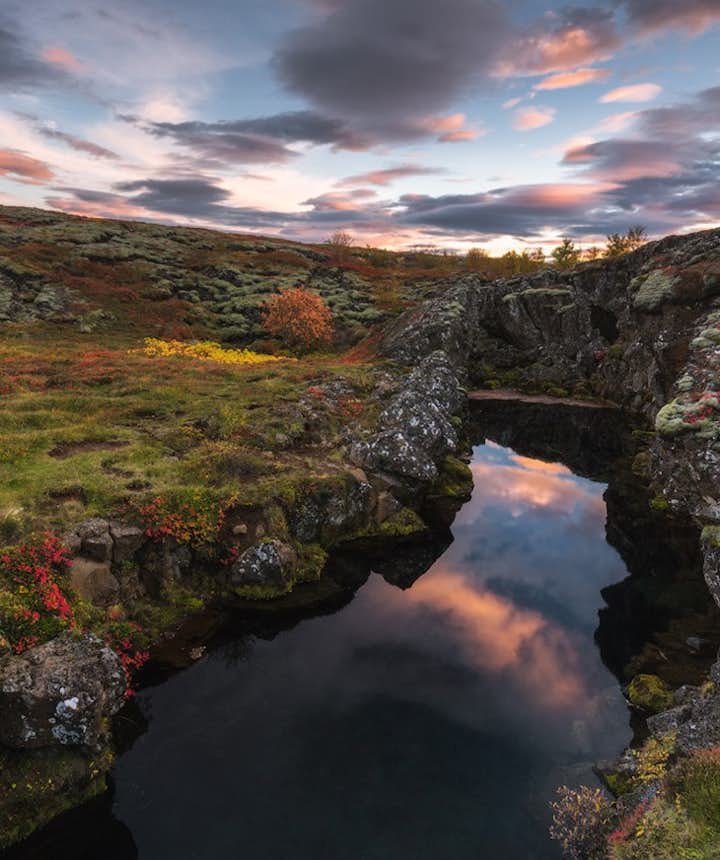 A ravine at Thingvellir National Park in Iceland with fall colors and the sun setting