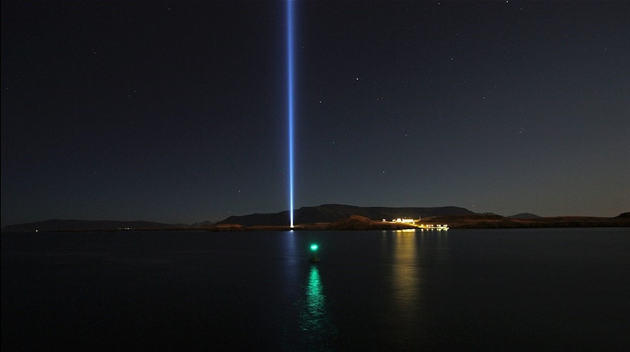 La Torre de Luz 'Imagina la Paz' en Videy, Reikiavik, encendida en un cielo nocturno estrellado