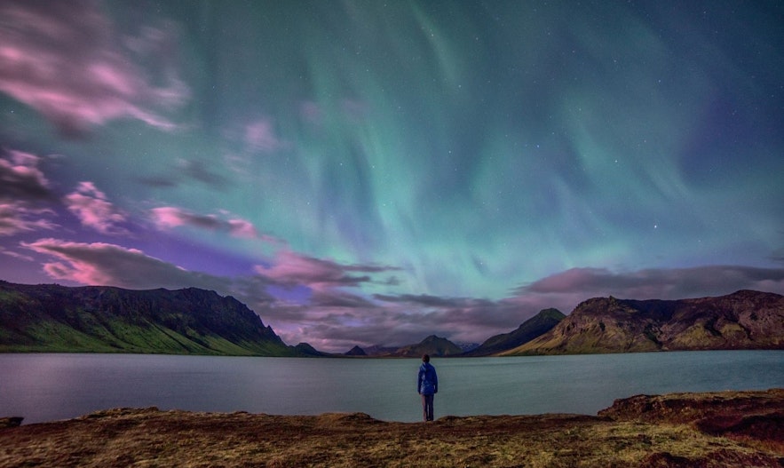 คนที่อยู่ท่ามกลางธรรมชาติเพื่อชมแสงเหนือในช่วงฤดูใบไม้ร่วงในประเทศไอซ์แลนด์