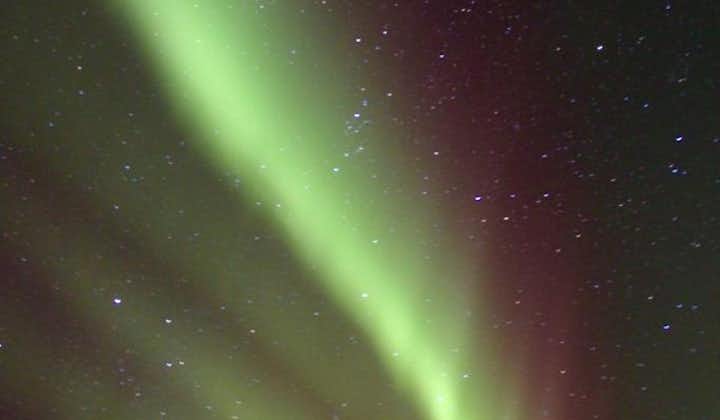 The northern lights shine in the sky in Iceland.
