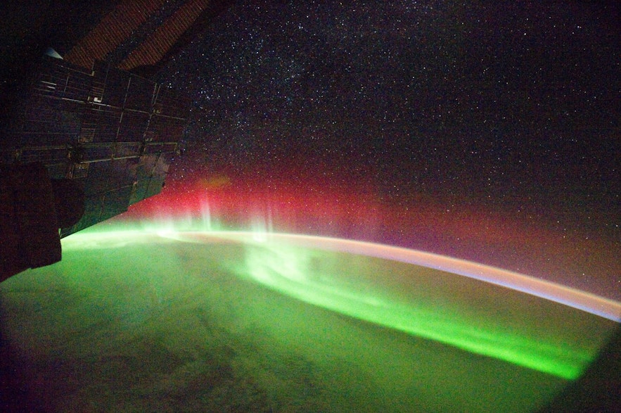Aurora borealis seen from the international space station ISS showing the northern lights in green, red, pink, orange, blue and white