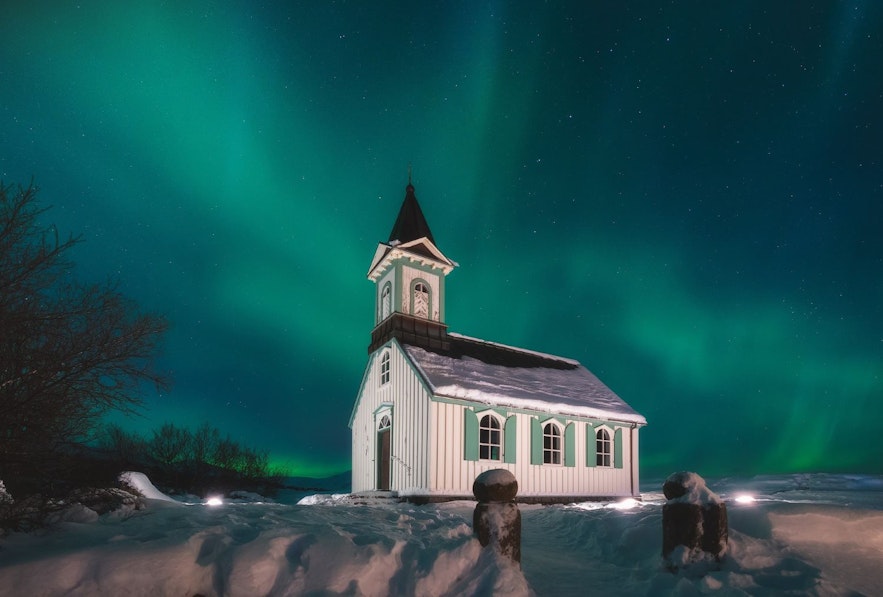 Thingvallakirkja Church in winter with the northern lights in the background
