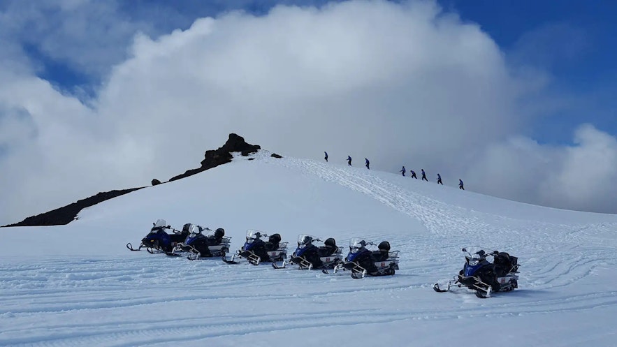 Snowmobiles and adventurers atop the icy plains of the Vatnajokull glacier.