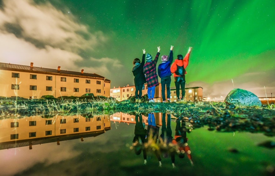人们在冰岛凯夫拉维克机场附近的Asbru观赏北极光